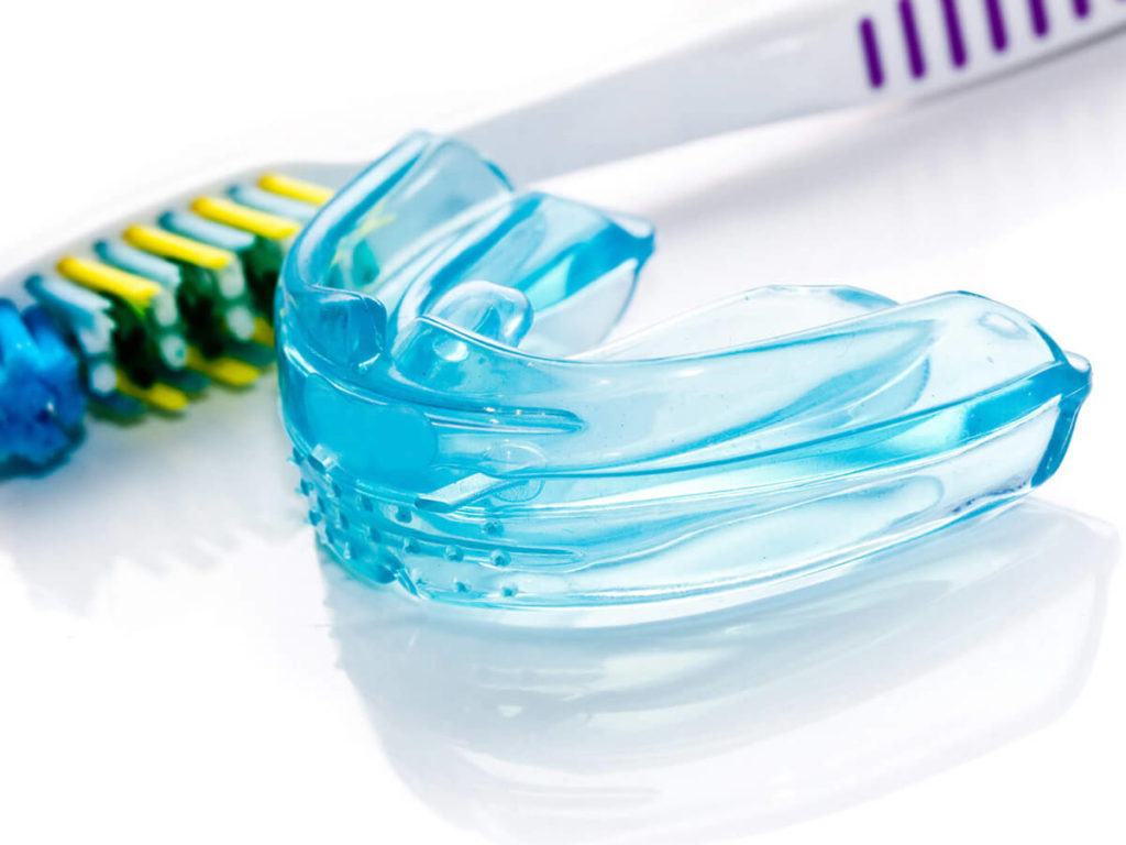 photo of a blue retainer and a toothbrush